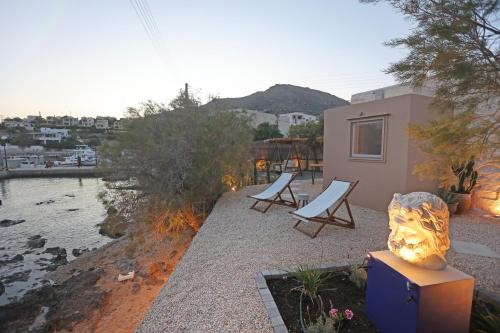 a house with two chairs and a sculpture next to a river at Maistrali Studio Ostria in Parakopí