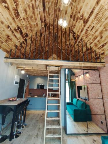 a room with a loft bed and a kitchen at Stania Loft CENTRUM in Boszkowo-Letnisko