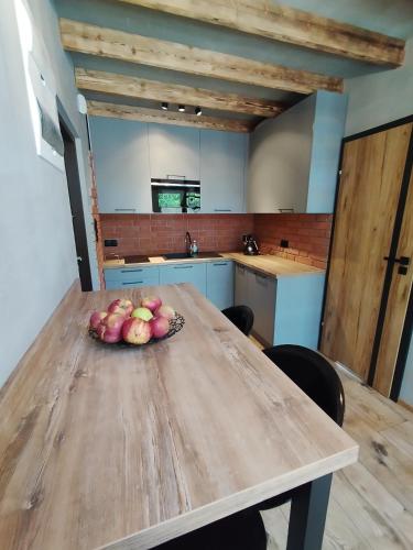 a bowl of apples on a wooden table in a kitchen at Stania Loft CENTRUM in Boszkowo-Letnisko