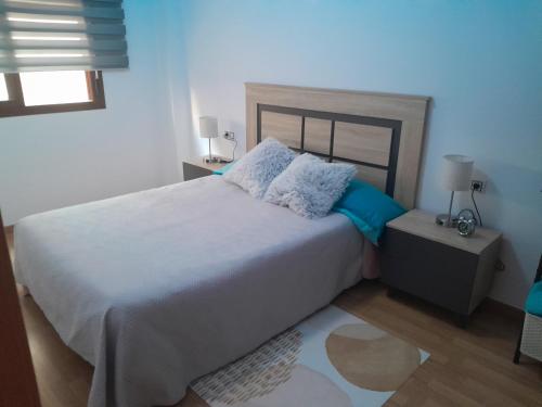 1 dormitorio con 1 cama blanca grande con almohadas azules en IM80, en Mont-roig
