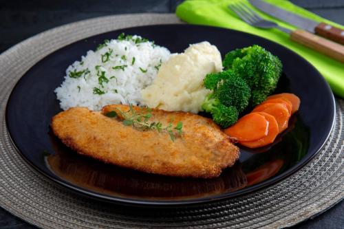a plate of food with rice broccoli and carrots at Luxury Motel in Sorocaba