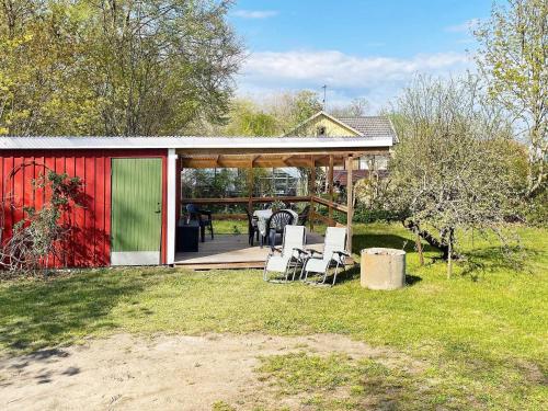 a house with a red and green building with chairs at 4 person holiday home in SÖLVESBORG-By Traum in Sölvesborg