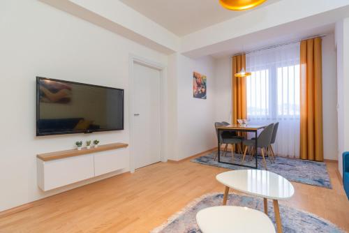 a living room with a table and a tv at Aria Pearl Apartment in Bitola