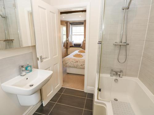 a bathroom with a sink and a shower and a toilet at Katie's Cottage in Skipton