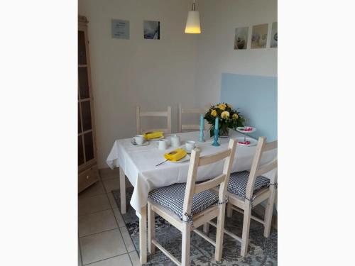 un tavolo bianco con due sedie e un vaso di fiori di Baltic Sea Modern retreat a Schönwalde am Bungsberg