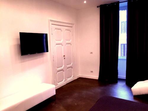 a living room with a couch and a tv on a wall at I LOVE ROMA Guest House in Rome