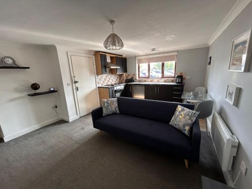 a living room with a couch and a kitchen at Whittlesey town centre apartment in Peterborough