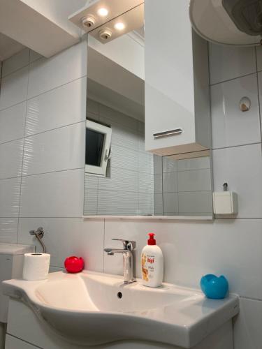 een badkamer met een wastafel en een spiegel bij Aine Apartman - Old Bridge in Mostar