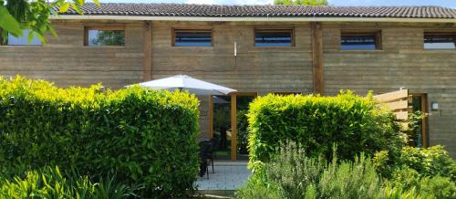 a house with an umbrella in front of it at Buddleia in Cherbonnières