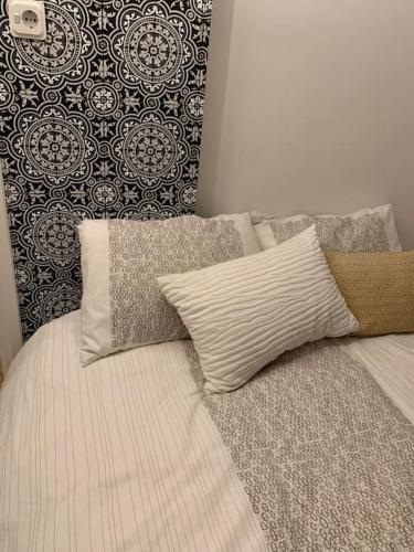 a bed with pillows on it with a wall at Nice house with swimming pool near Maastricht in Bunde