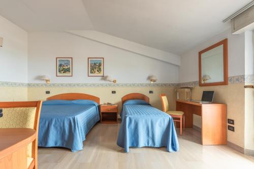 a hospital room with two beds and a desk at Hotel Touring in Falconara Marittima