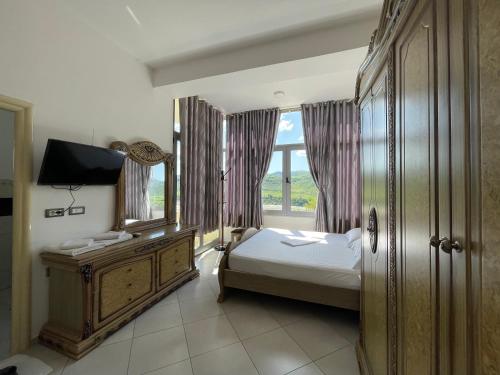 a bedroom with a bed and a large window at Hotel Latifi in Gramsh