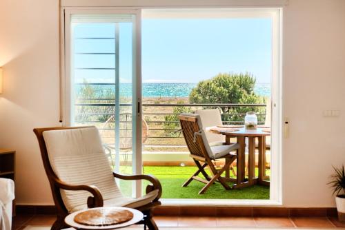 a room with a balcony with a table and chairs at Casa frente al mar con piscina privada in Sagunto