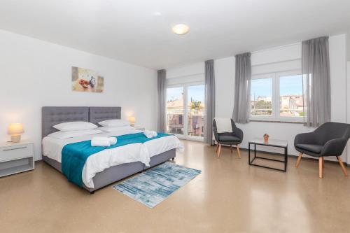 a bedroom with a large bed and two chairs at Villa Grace in Rovinj