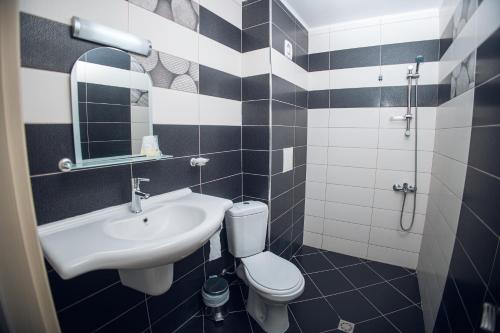 a bathroom with a sink and a toilet and a mirror at Хотел и Вили Марая apartament in Tsarevo