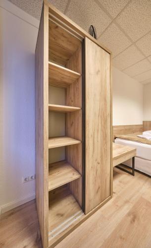 um armário com prateleiras de madeira num quarto em sleep1c em Hamburgo