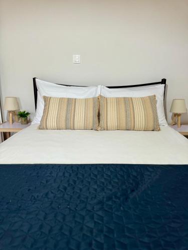 a white bed with two pillows and two lamps at Captain Christos Family Garden House in Lefkimmi