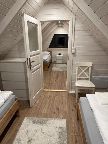 a small attic room with two beds and a door at Siedlisko Leśnica - domki całoroczne Brenna in Brenna