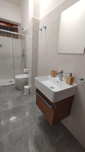 a bathroom with a sink and a shower and a toilet at R Family in Acireale