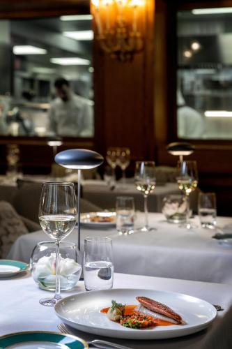 a table with a plate of food and wine glasses at Baglioni Hotel Luna - The Leading Hotels of the World in Venice