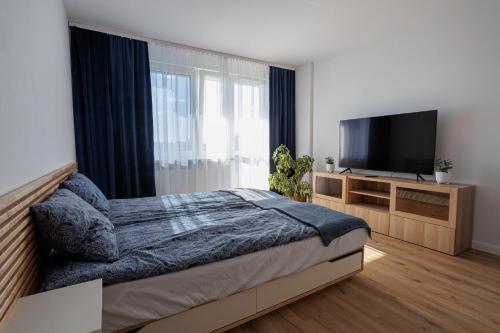 um quarto com uma cama e uma televisão de ecrã plano em Oboźna 25 em Zamość