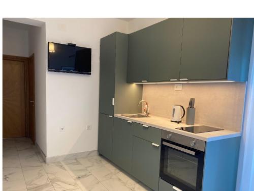 uma cozinha com armários verdes e um lavatório em Apartment Lena em Vodice
