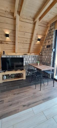 Vila Vuk في زبلجك: غرفة بها مدفأة وطاولة وكراسي