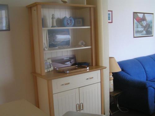 - un salon avec une télévision et un canapé bleu dans l'établissement vue sur le bassin d'arcachon, à Arcachon