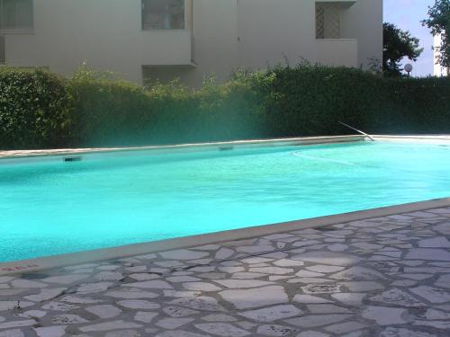 une piscine avec de l'eau bleue devant un immeuble dans l'établissement vue sur le bassin d'arcachon, à Arcachon