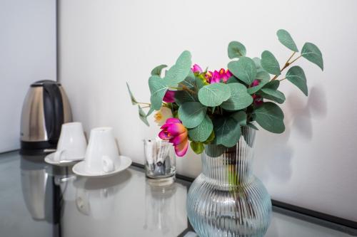a glass vase with flowers on a table at Skalinada Sea View in Lokva Rogoznica