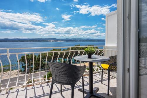 a balcony with a table and chairs and a view of the water at Skalinada Sea View in Lokva Rogoznica