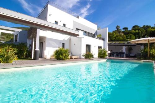 une villa avec piscine devant une maison dans l'établissement Villa Luxueuse à Cavalaire-sur-Mer, à Cavalaire-sur-Mer