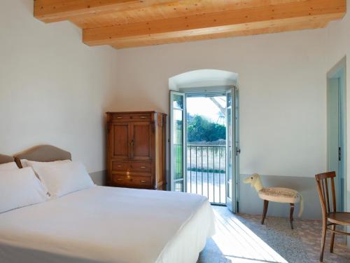 a bedroom with a white bed and a balcony at I Casali del Pino in La Giustiniana