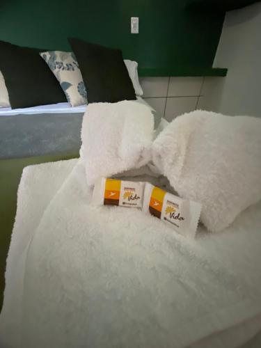 een stapel witte handdoeken bovenop een bed bij Pousada La Luna in Paracuru