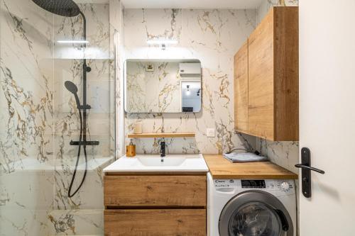 La petite salle de bains est pourvue d'un lavabo et d'un lave-linge. dans l'établissement Montfleury cannes, à Cannes