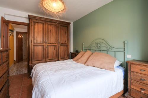 sypialnia z dużym łóżkiem i drewnianą komodą w obiekcie Casa Evita w mieście Estepona