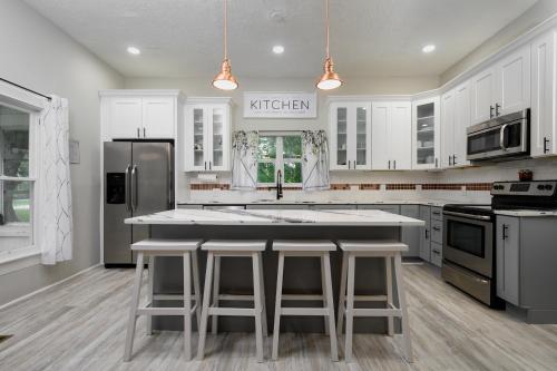 a kitchen with white cabinets and a kitchen island with stools at Historic home lake access, near parks and venues in Winter Haven