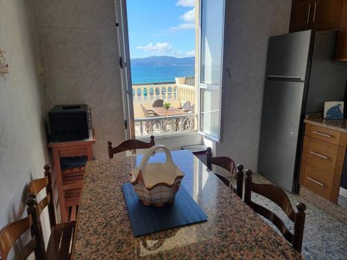 a kitchen with a table with a view of the ocean at Ventana al Atlantico - House across from the beach in Porto do Son