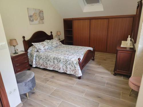 a bedroom with a bed and a wooden floor at Ventana al Atlantico - House across from the beach in Porto do Son