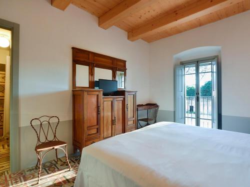 a bedroom with a large bed and a chair at I Casali del Pino in La Giustiniana