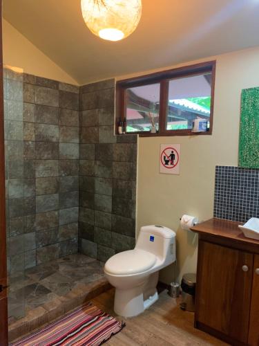 a bathroom with a toilet and a shower at Brigitte's Ranch in Cahuita