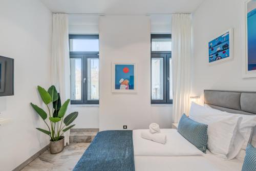 een witte slaapkamer met een bed en een bank bij Tango Rooms in Split