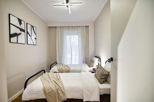 a bedroom with two beds and a window at Apartament Indigo 11 by Housine in Zator