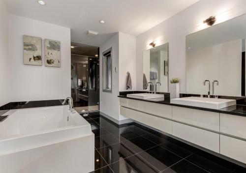 a bathroom with two sinks and two mirrors at Newly Renovated Vacation Home w/ Hot Tub & Garage in Calgary