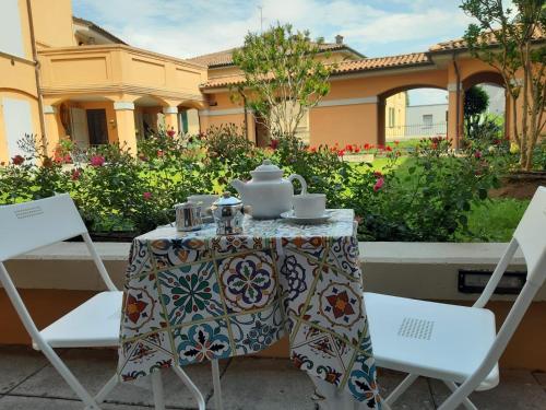 uma mesa e cadeiras com um conjunto de chá em A Casa San Pietro - bilocale centro storico - Cyclist-friendly em Castel San Pietro Terme