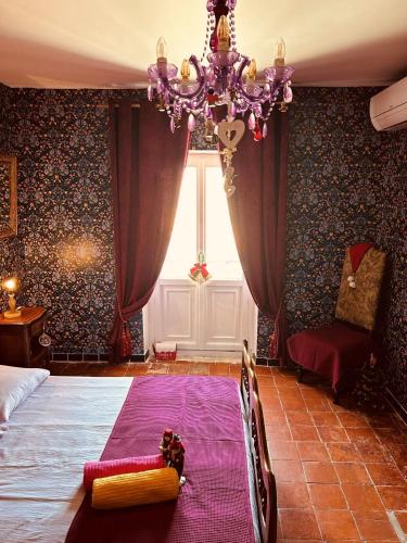 une chambre avec un lit et un lustre dans l'établissement La Babayaga, à Capestang
