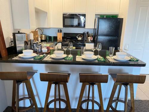 a kitchen with a counter with chairs and a table with glasses at Dog friendly Mid-Century style condo with poolspa in La Quinta