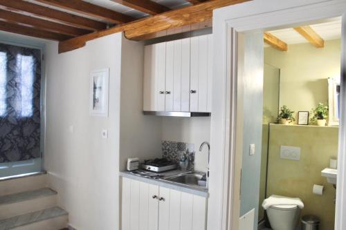 a bathroom with white cabinets and a sink and a toilet at Διώροφη κατοικία Γλώσσα Σκοπέλου in Skopelos Town
