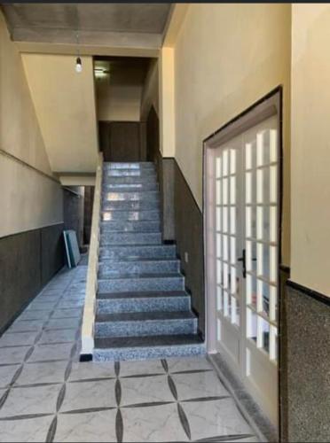 um corredor com escadas num edifício com uma porta em Résidence Palestine 