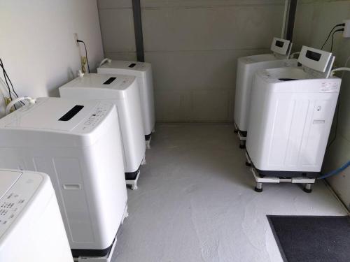 a room with four sinks and washing machines in it at ５８ビレッジ種子島 in Ishidera